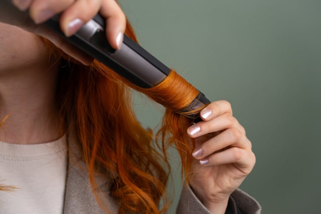 Crafting Captivating Headlines: Your awesome post title goes here Close-up of a woman curling her vibrant red hair with a curling iron.